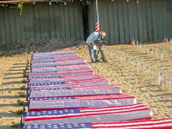 ArlingtonWest Flag draped coffins on beach.